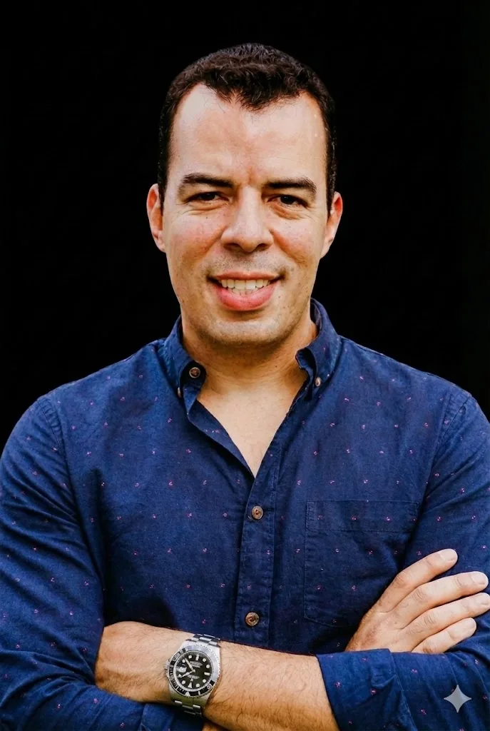 Leandro Souza, mentor financeiro da LUCROBLINDADO, de braços cruzados sorrindo, camisa azul